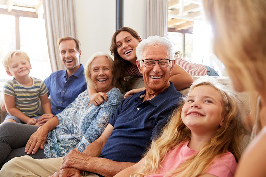 About Our Agency - Extended Family Sitting in the Living Room Having Fun Talking Together